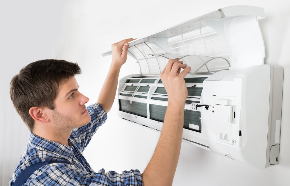Male Technician Cleaning Air Conditioning System